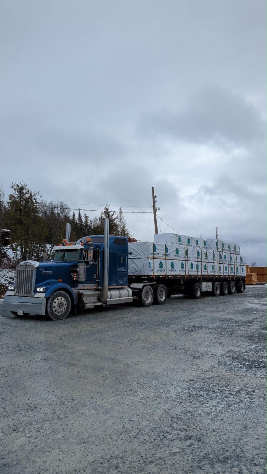 Flatbed loaded with wrapped lumber packs