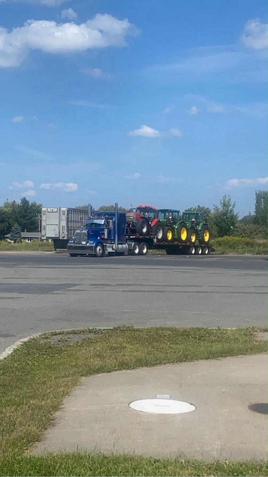 Step deck hauling farm tractors and equipment